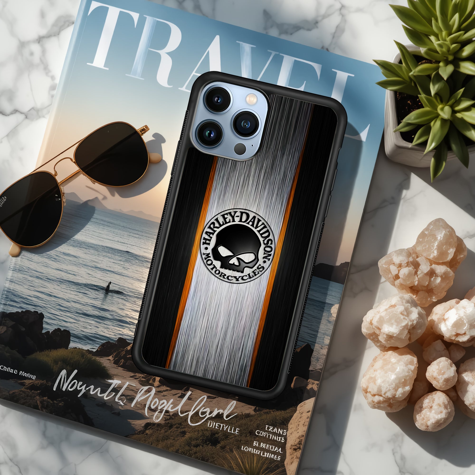 Phone case with Harley Davidson logo on a travel magazine with sunglasses and succulents.